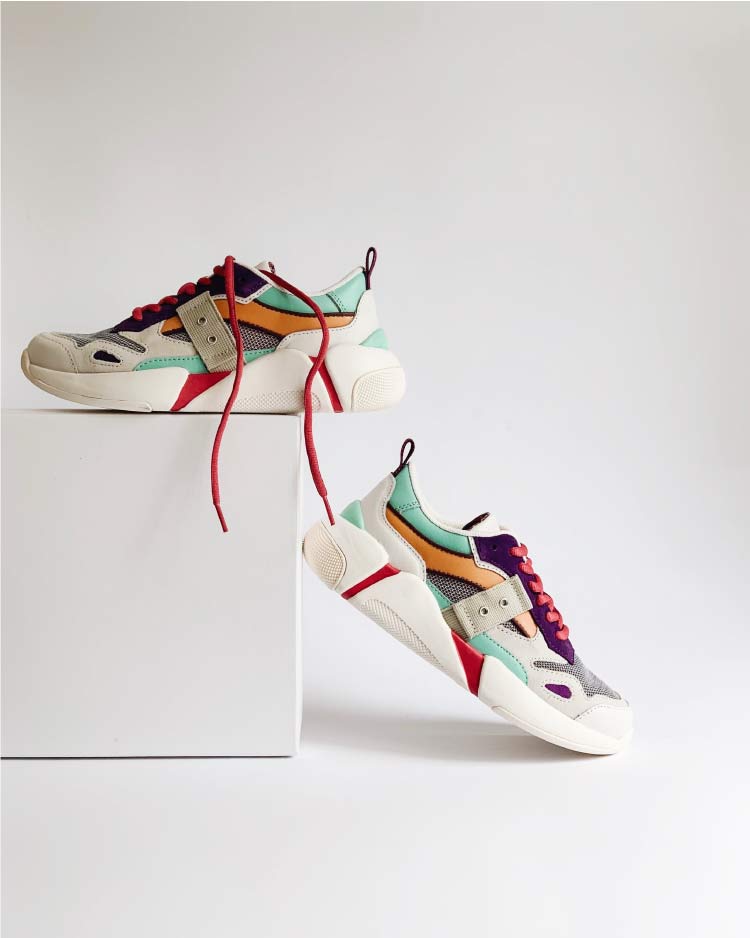 Leather basketball sneakers with purple, yellow, grey, and green detailing, chunky white rubber soles, and red laces.
